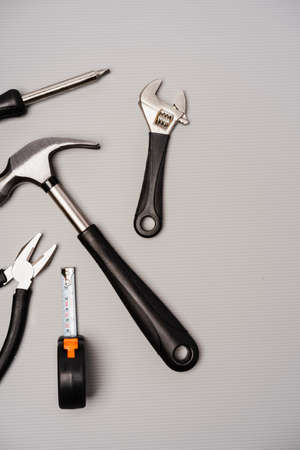 Flat lay composition of a set of tools, including hammer, pliers, wrench, screwdrivers and measuring...
