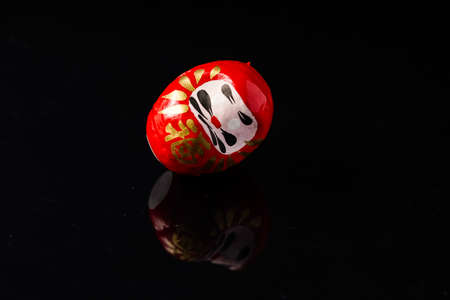 Daruma Doll isolated against black