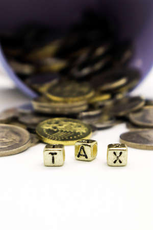 âTAXâ wording on a stack of coins, isolatedの写真素材