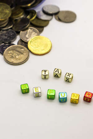 âTAXâ wording on a stack of coins, isolatedの写真素材