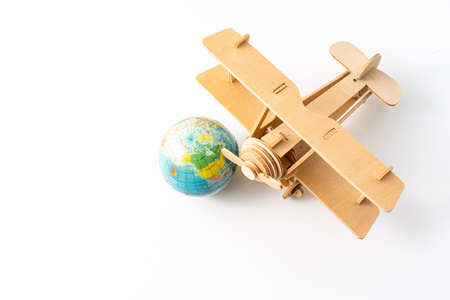 Miniature wooden aeroplane with a mini globe. Travel conceptの写真素材