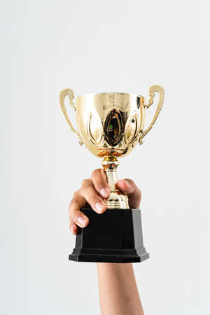 A manâs hand holding a trophy against isolated white backgroundの写真素材