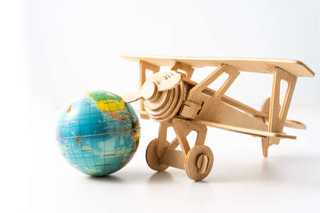Miniature wooden aeroplane with a mini globe. Travel conceptの写真素材