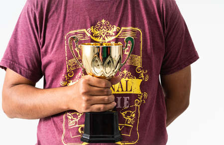 A manâs hand holding a trophy against isolated white backgroundの写真素材