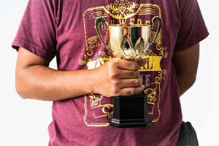 A manâs hand holding a trophy against isolated white backgroundの写真素材