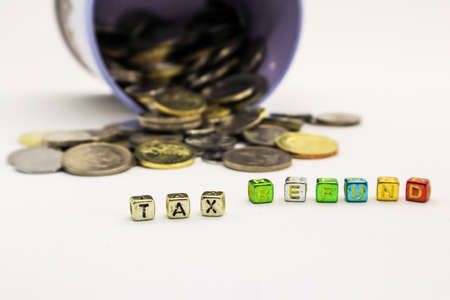 âTAXâ wording on a stack of coins, isolatedの写真素材