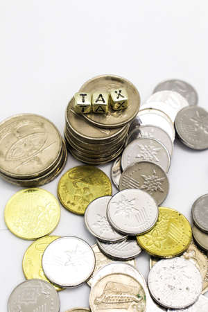 âTAXâ wording on a stack of coins, isolatedの写真素材