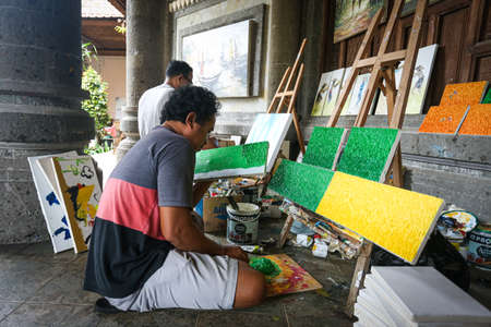 Balinese painter at work to produce paintings and artwork at a galleryのeditorial素材