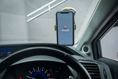 An iPhone X with Waze navigation app inside the car. Waze has gain popularity for its good navigation.のeditorial素材
