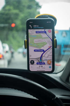 An iPhone X with Waze navigation app inside the car. Waze has gain popularity for its good navigation.のeditorial素材