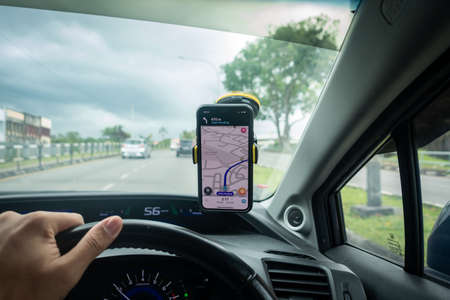 An iPhone X with Waze navigation app inside the car. Waze has gain popularity for its good navigation.のeditorial素材