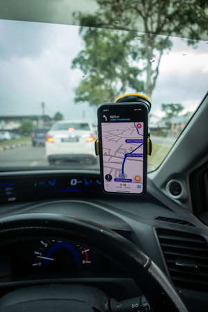 An iPhone X with Waze navigation app inside the car. Waze has gain popularity for its good navigation.のeditorial素材
