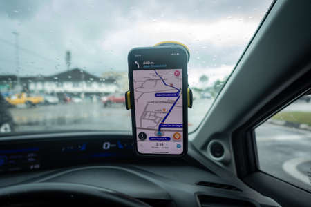 An iPhone X with Waze navigation app inside the car. Waze has gain popularity for its good navigation.のeditorial素材