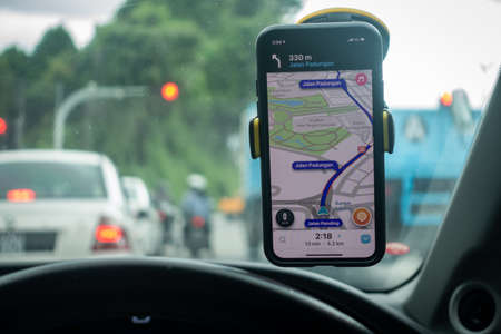 An iPhone X with Waze navigation app inside the car. Waze has gain popularity for its good navigation.のeditorial素材
