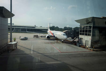 Malaysia Airlines planes prepare for passengers to board, as ground crew prepares the plane for the...