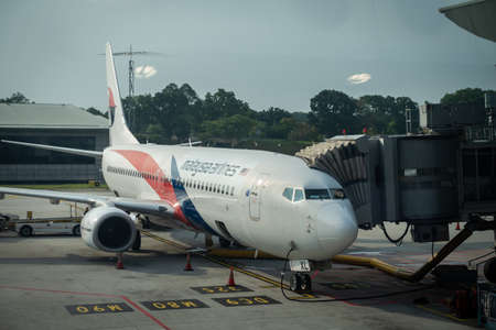 Malaysia Airlines planes prepare for passengers to board, as ground crew prepares the plane for the flightのeditorial素材