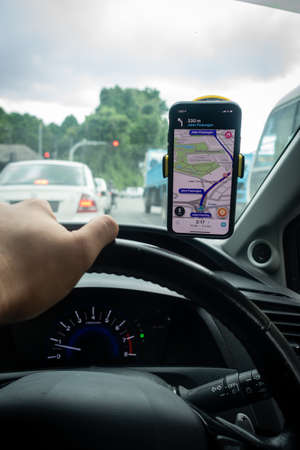 An iPhone X with Waze navigation app inside the car. Waze has gain popularity for its good navigation.のeditorial素材