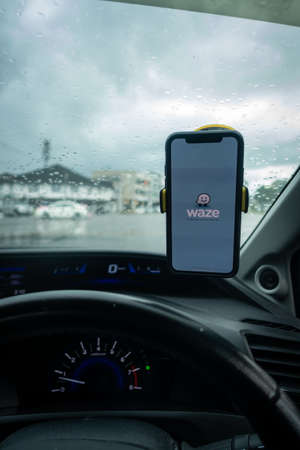 An iPhone X with Waze navigation app inside the car. Waze has gain popularity for its good navigation.のeditorial素材