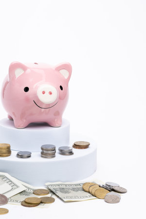 Piggy bank with scattered coins on white backgroundの写真素材