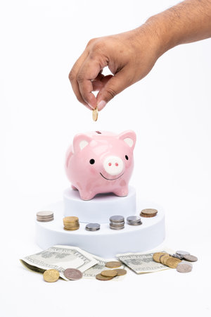 Piggy bank with scattered coins on white backgroundの写真素材