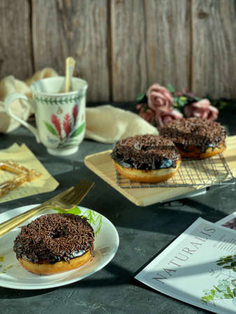 Chocolate Sprinkled Doughnuts during tea time. Vintage styleの写真素材