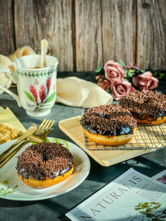 Chocolate Sprinkled Doughnuts during tea time. Vintage styleの写真素材
