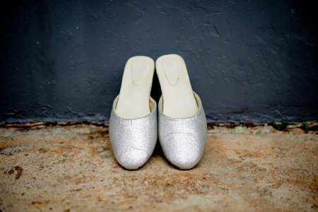 wedding shoes on the floor in front of the gray wallの写真素材