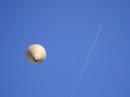 Airplane and hot air balloon on a blue skyの写真素材