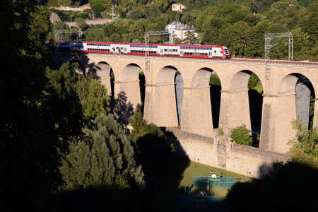 Passenger trainset on an old viaduct in Luxembourg cityの写真素材