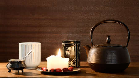 Tea cup, tea pot, candle, box with tea leaves and tiny bowl with honeyの写真素材