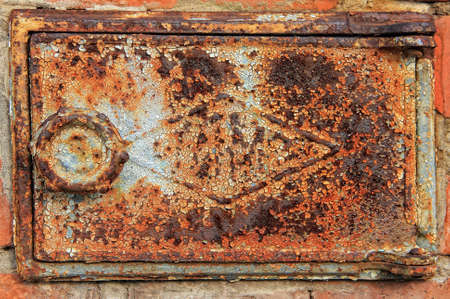 a rusty iron door of a flue 