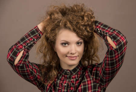The beautiful girl lifts the long hair upwards.