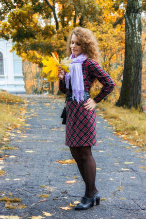 The girl walks in autumn park.の写真素材