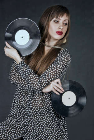 The young woman holds phonograph records の写真素材