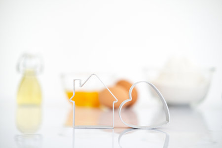 Bakery products.Dessert ingredients on white reflect table background . Front view. Copy space. egg, flour, milk, oil, cookies cutter.の写真素材