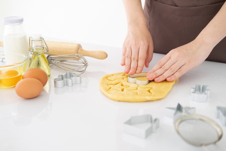 Making for homemade biscuits. On the table is dough and a set of cookie molds with other kitchen equipment. Cute baby cookies in the shape of  a heart and a tree. Cooking with baking tools.Top view. Copy Spaceの写真素材