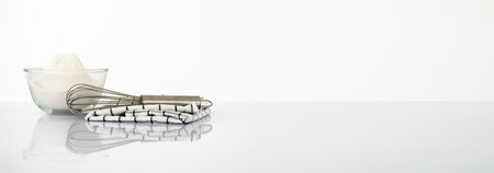 Wide horizontal Panorama cover and header web Banner. Baking concept. Bowl with a whisk and dishcloth on white table over white background with copy space.の写真素材