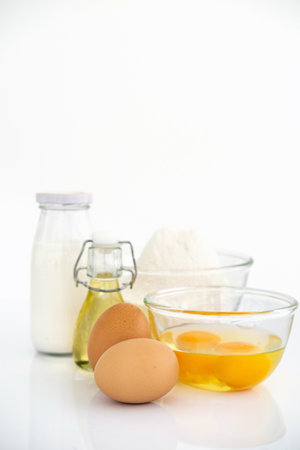 Wheat flour with eggs, oil and milk on table . White table Front view copyspaceの写真素材