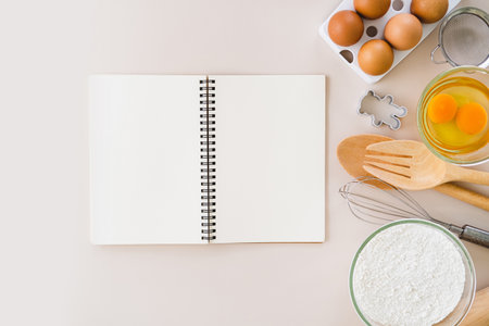 Blank recipe cooking book white baking ingredients and utensils on pink background. Top view with copy space.の写真素材