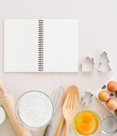 Simple home cooking - top view of blank cook book  and wooden kitchen tool on white background.  copy spaceの写真素材