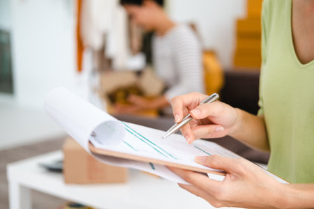 closeup hand Starting small businesses SME owners, Asian woman check online orders Selling products online and working with boxes freelance work at home Asian sme business online small medium enterpriseの写真素材