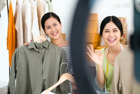 Asia vlogger woman influencer, SME retail store owner smile enjoy selling show live sale online screen in IG story reel tiktok work at home studio. Gen Z people record viral video selfie shoot app.の写真素材