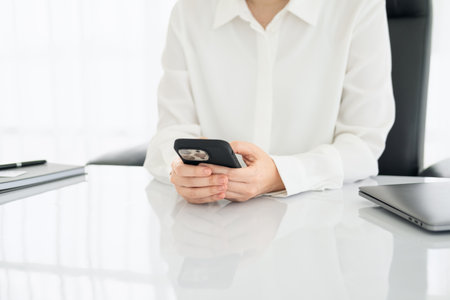 Young businesswoman working at the office for investment analyzing company financial report balance with smart phone. Concept for young entrepreneur and start up.の写真素材