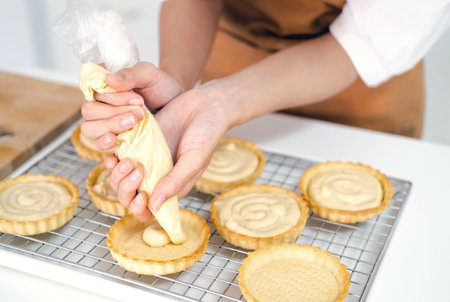 close up hands of Small business entrepreneur asian woman bakery shop making fruit tart. Female...