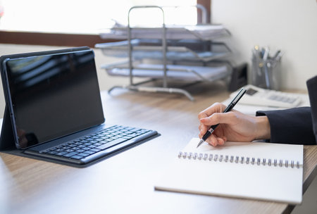 Business woman working at office with laptop and documents on his desk, Business woman holding pens and papers making notes in documents on the table, Hands of financial manager taking notesの写真素材
