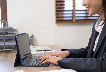 Woman sitting at desk and working at computer hands close upの写真素材