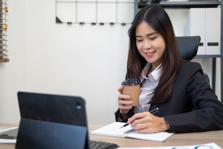 Thinking about how to take the business to technological heights. Cropped shot of an attractive young businesswoman working in her office.の写真素材