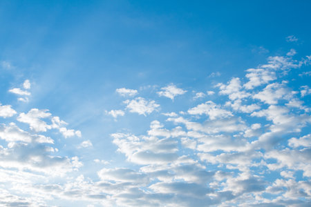 Blue sky background with tiny cumulus cloudsの写真素材