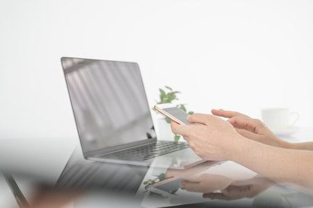 Woman hands using smartphone and laptop computer for online shopping at home, Hand holding mobile...