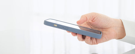 Closeup of business man hand using mobile smart phone and reading message via application while...